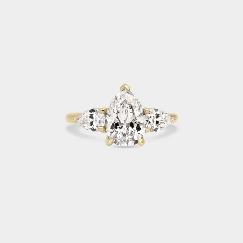 Halo - Style Women's Diamond Rings with a Center Diamond Surrounded by Smaller Diamonds in 18K GoldTrio of Pear Diamond